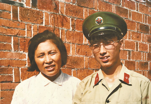 1986年6月，韦昌进从前线返回老家，和母亲汪生兰在自家房屋前合影